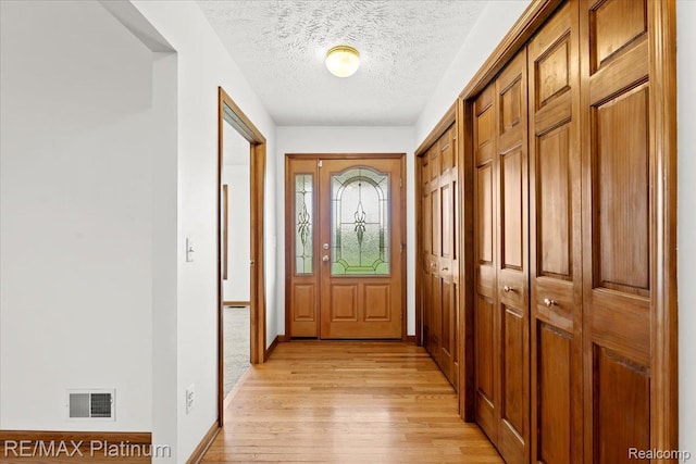 6893 Sanford Rd, Howell, MI 48855 - entrance foyer with light wood-type flooring and a textured ceiling