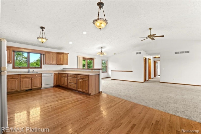 6893 Sanford Rd, Howell, MI 48855 - kitchen with a textured ceiling, open floor plan, a peninsula, light countertops, and hanging light fixtures