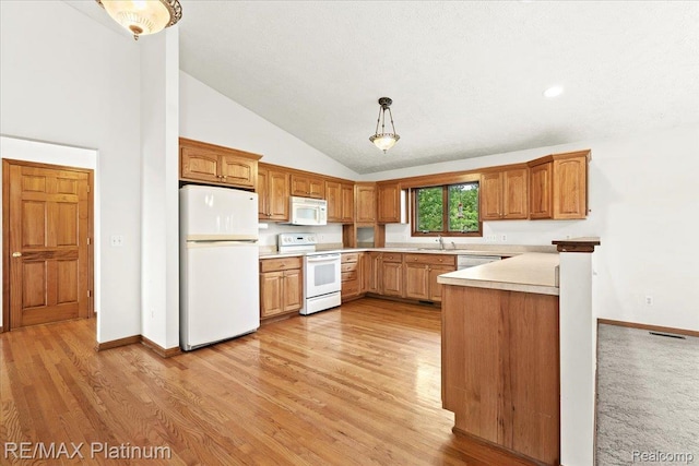 6893 Sanford Rd, Howell, MI 48855 - kitchen with white appliances, light countertops, light wood-style floors, pendant lighting, and high vaulted ceiling