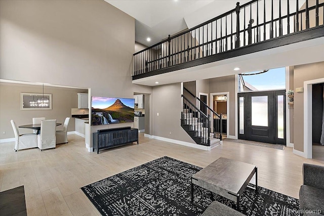 15924 Myrtle Dr, Macomb, MI 48042 - living area featuring stairs, a towering ceiling, a chandelier, light wood-style flooring, and recessed lighting