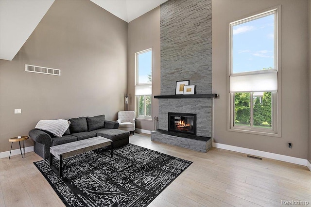 15924 Myrtle Dr, Macomb, MI 48042 - living room featuring a high ceiling, wood finished floors, and a stone fireplace