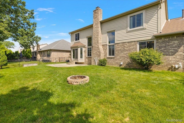 15924 Myrtle Dr, Macomb, MI 48042 - rear view of house with a chimney, a fire pit, brick siding, and a patio area