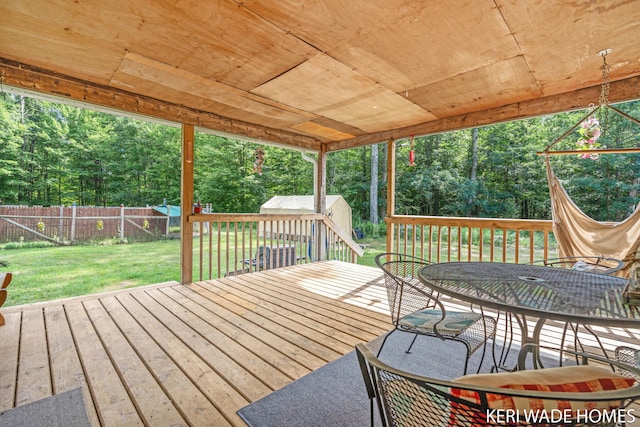 3231 E Baker Rd, Hesperia, MI 49421 - deck with a fenced backyard, a storage unit, view of scattered trees, and outdoor dining area