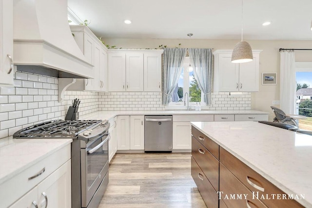6129 W Bay Ct, Hudsonville, MI 49426 - kitchen with appliances with stainless steel finishes, custom exhaust hood, white cabinets, light wood-style floors, and recessed lighting