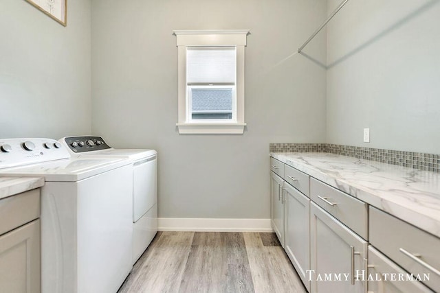 6129 W Bay Ct, Hudsonville, MI 49426 - washroom with washer and clothes dryer, light wood-style floors, and cabinet space