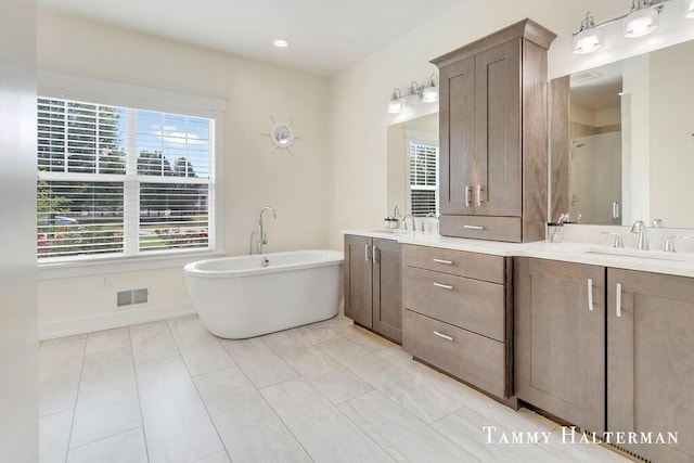 6129 W Bay Ct, Hudsonville, MI 49426 - full bathroom with double vanity, a freestanding tub, and a shower with door