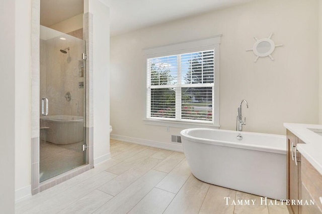 6129 W Bay Ct, Hudsonville, MI 49426 - full bathroom featuring vanity, a soaking tub, and a stall shower