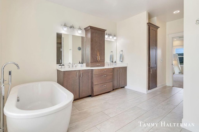 6129 W Bay Ct, Hudsonville, MI 49426 - bathroom featuring a freestanding bath and double vanity