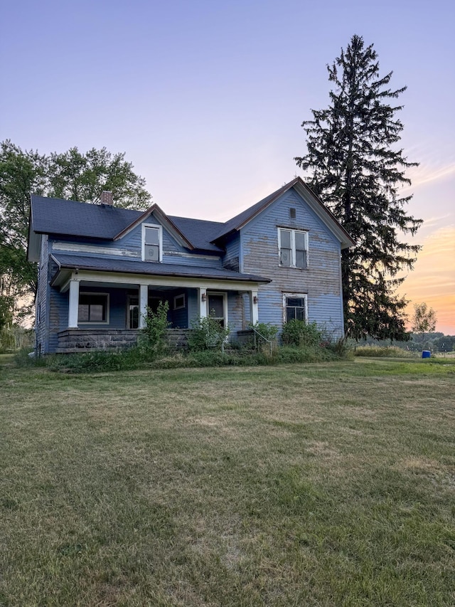 10677 Mason Dr, Grant, MI 49327 - view of front of property featuring a front yard, covered porch, and a chimney