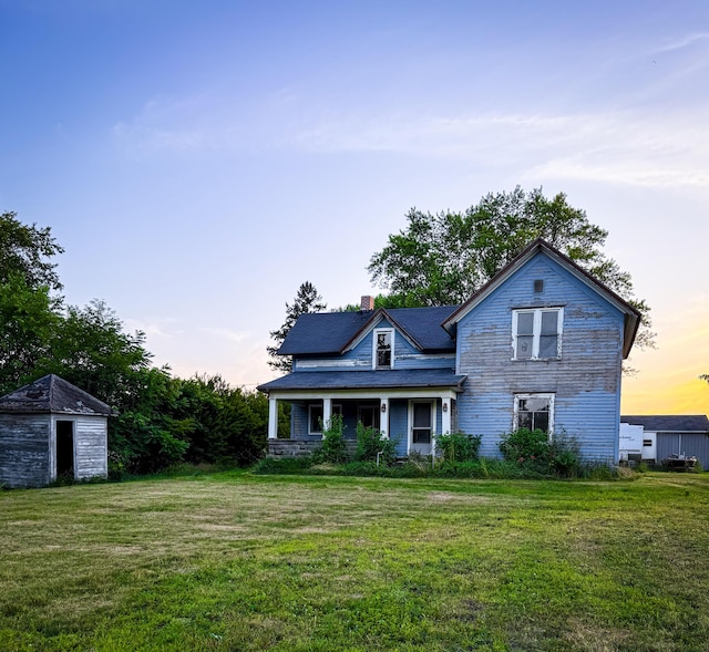 10677 Mason Dr, Grant, MI 49327 - view of front of home featuring a lawn, a shed, a chimney, and a porch