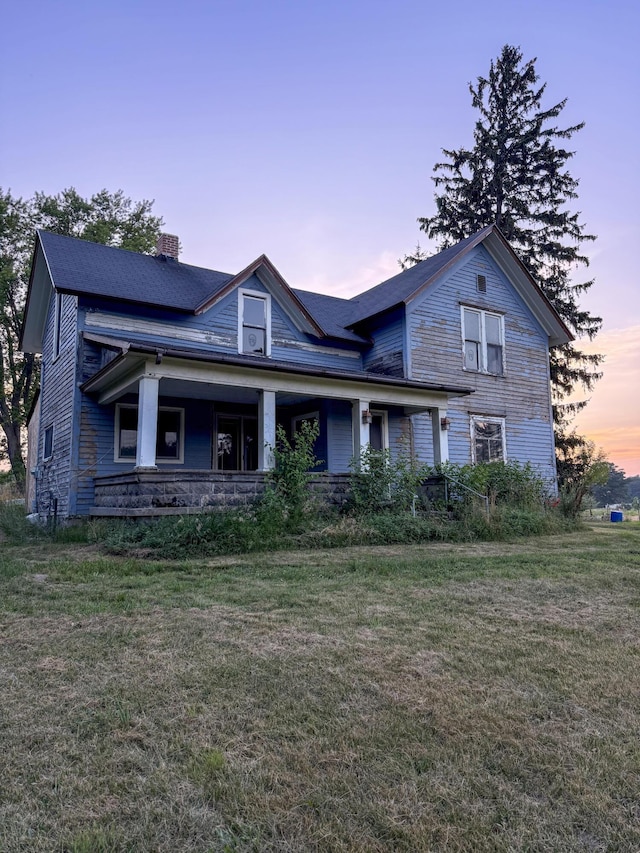 10677 Mason Dr, Grant, MI 49327 - view of front of house with a chimney, a front yard, and covered porch