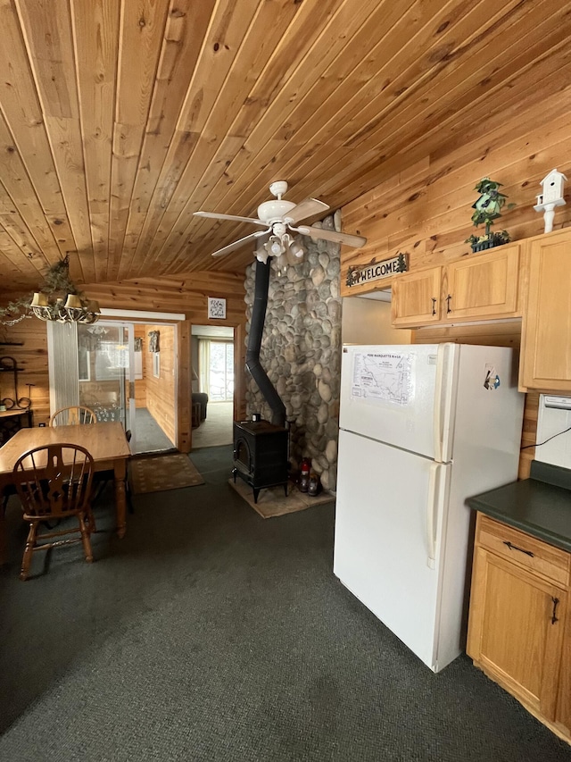 9279 S Forman Rd, Baldwin, MI 49304 - kitchen featuring freestanding refrigerator, a wood stove, dark carpet, a ceiling fan, and wood ceiling