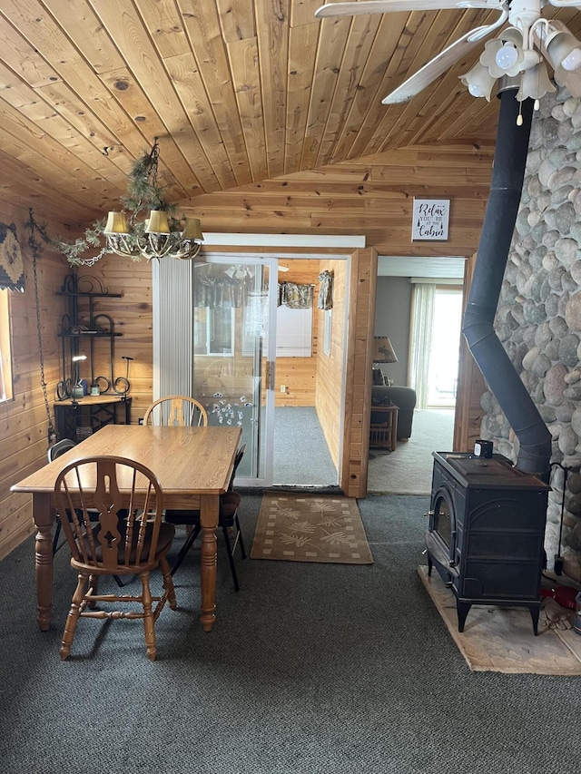 9279 S Forman Rd, Baldwin, MI 49304 - carpeted dining area with wood walls, vaulted ceiling, a wood stove, a ceiling fan, and wooden ceiling