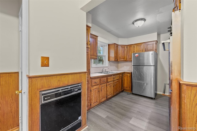 8460 Busko Ave, Utica, MI 48093 - kitchen featuring freestanding refrigerator, black dishwasher, a wainscoted wall, brown cabinets, and light countertops