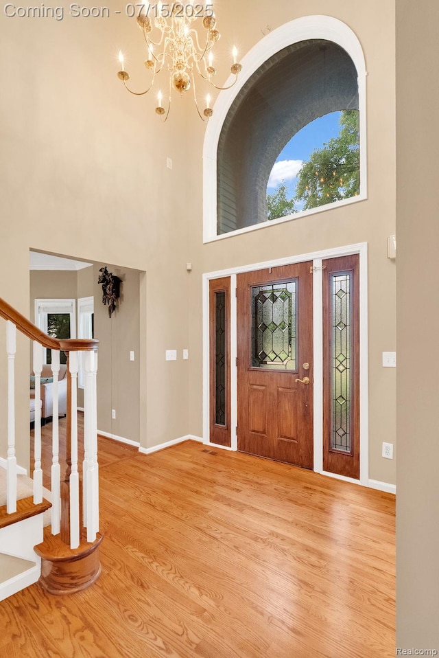 11656 Kings Colony, Grand Blanc, MI 48439 - entryway featuring a towering ceiling, light wood-type flooring, a chandelier, and stairway