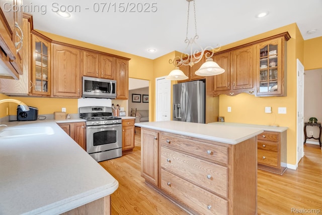 11656 Kings Colony, Grand Blanc, MI 48439 - kitchen featuring stainless steel appliances, a kitchen island, light wood-style flooring, light countertops, and glass insert cabinets