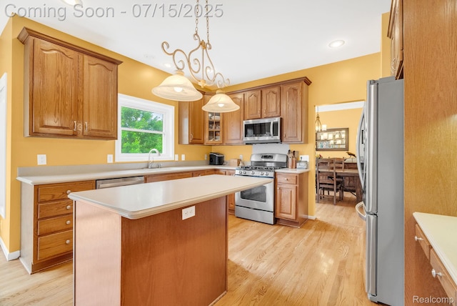 11656 Kings Colony, Grand Blanc, MI 48439 - kitchen featuring stainless steel appliances, light wood-style floors, a center island, light countertops, and brown cabinets