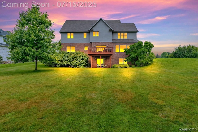 11656 Kings Colony, Grand Blanc, MI 48439 - back of property at dusk with brick siding, a lawn, and a deck