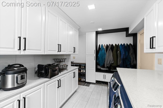 61353 W 8 Mile Rd, South Lyon, MI 48178 - kitchen with white cabinets, tasteful backsplash, and light tile patterned flooring