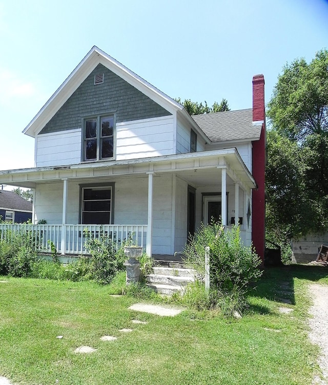 1111 S Main St, Three Rivers, MI 49093 - view of front facade with covered porch, a chimney, and a front lawn