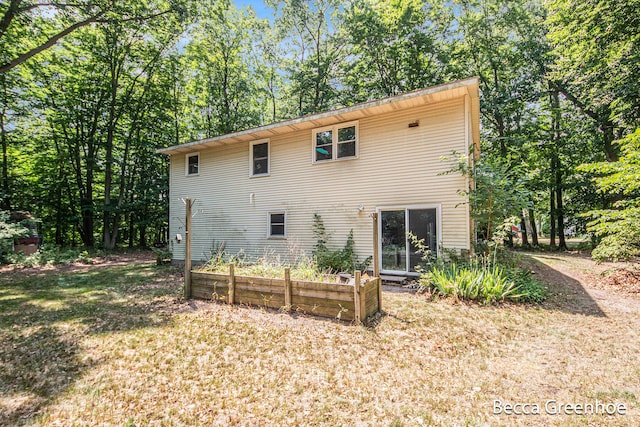 14180 168th Ave, Grand Haven, MI 49417 - view of home's exterior with a garden and a lawn