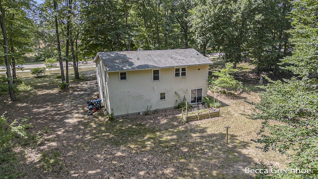14180 168th Ave, Grand Haven, MI 49417 - rear view of property featuring a vegetable garden and view of wooded area