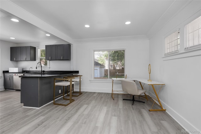 3921 Three Mile Dr, Detroit, MI 48224 - kitchen with dark countertops, a kitchen breakfast bar, a peninsula, light wood-type flooring, and recessed lighting