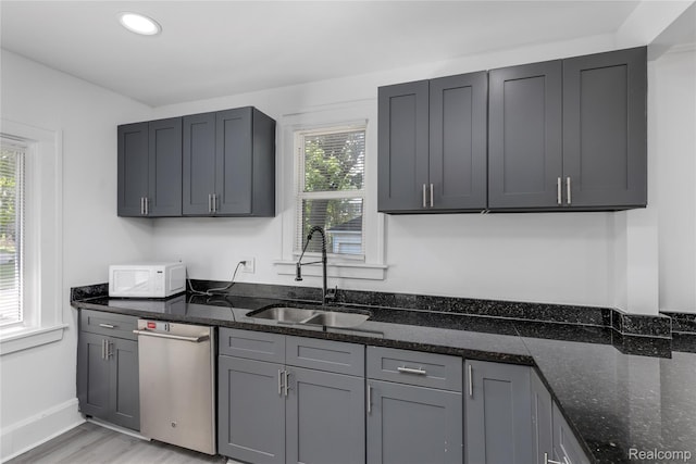 3921 Three Mile Dr, Detroit, MI 48224 - kitchen featuring dishwasher, white microwave, dark stone countertops, recessed lighting, and light wood-type flooring