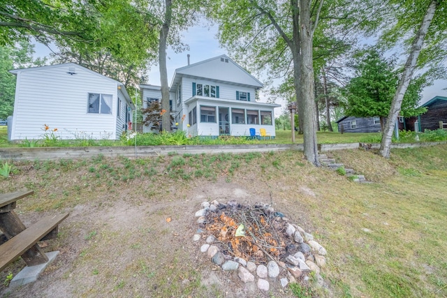 3110 13 Mile Rd, Remus, MI 49340 - back of property with a sunroom, an outdoor fire pit, and a yard