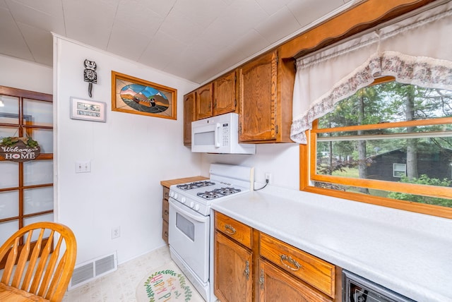 3110 13 Mile Rd, Remus, MI 49340 - kitchen featuring white appliances, light countertops, and brown cabinets