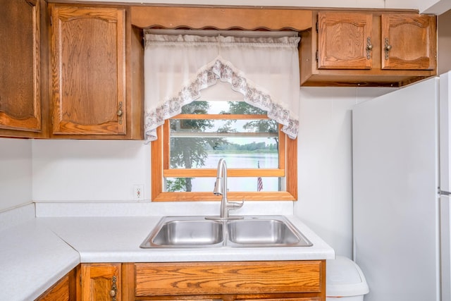3110 13 Mile Rd, Remus, MI 49340 - kitchen featuring freestanding refrigerator, light countertops, and brown cabinetry