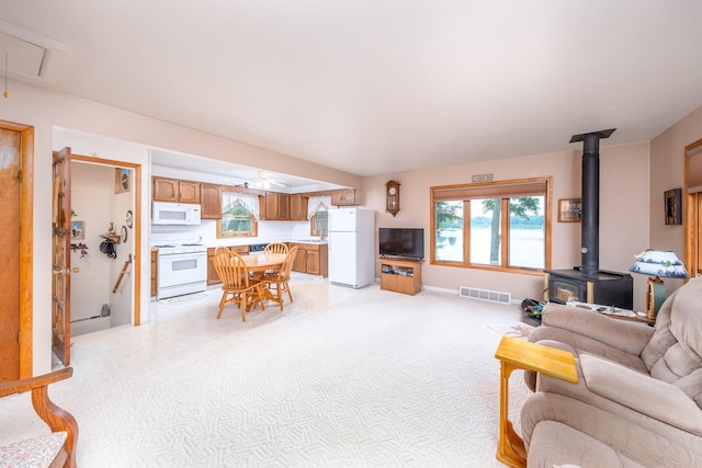 3110 13 Mile Rd, Remus, MI 49340 - living area with a wood stove, attic access, and ceiling fan