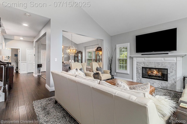 23331 Sawgrass Ct S, South Lyon, MI 48178 - living area with dark wood-type flooring, a chandelier, lofted ceiling, recessed lighting, and a fireplace