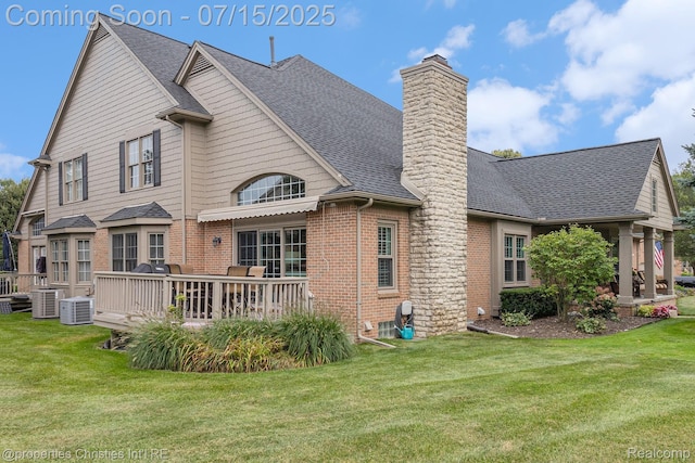 23331 Sawgrass Ct S, South Lyon, MI 48178 - back of house featuring brick siding, roof with shingles, and a yard