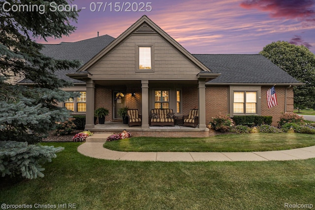23331 Sawgrass Ct S, South Lyon, MI 48178 - back of house with brick siding, a porch, a lawn, and roof with shingles