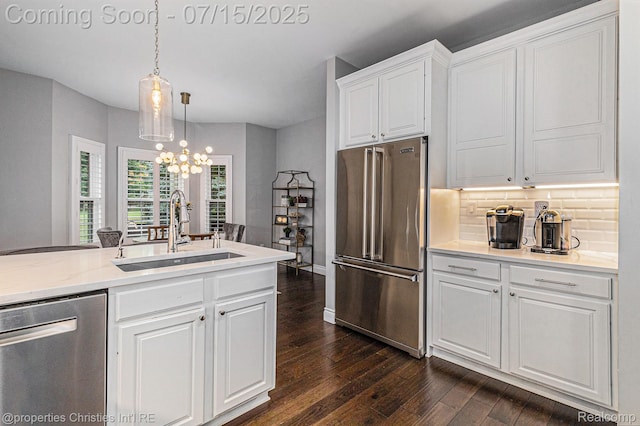 23331 Sawgrass Ct S, South Lyon, MI 48178 - kitchen with stainless steel appliances, dark wood-style flooring, white cabinets, a chandelier, and tasteful backsplash