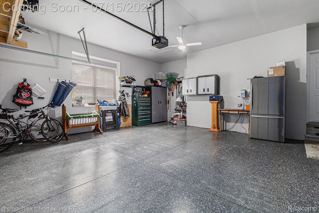 23331 Sawgrass Ct S, South Lyon, MI 48178 - garage featuring freestanding refrigerator, a garage door opener, a ceiling fan, and a workshop area