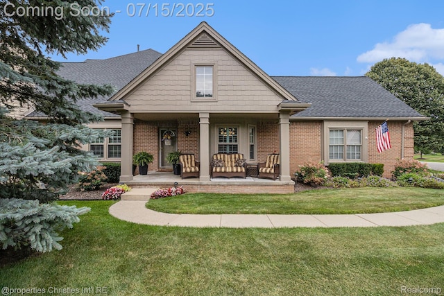 23331 Sawgrass Ct S, South Lyon, MI 48178 - view of front facade featuring brick siding, a porch, a front yard, and roof with shingles