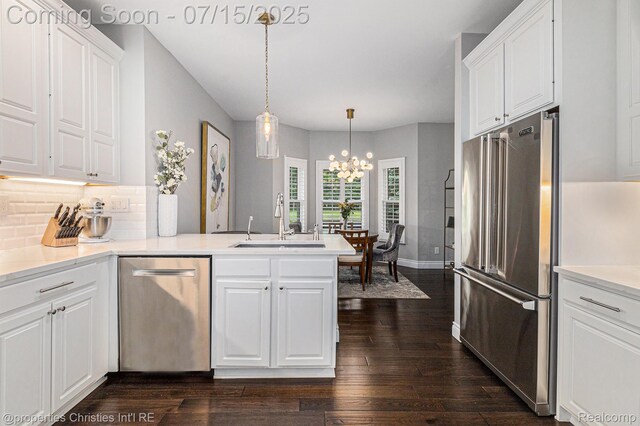 23331 Sawgrass Ct S, South Lyon, MI 48178 - kitchen with appliances with stainless steel finishes, white cabinetry, a peninsula, and a chandelier