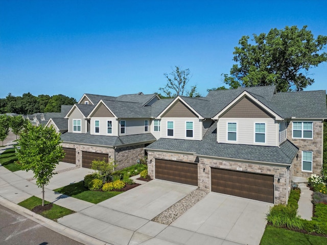 3064 N Spurway Dr, Ann Arbor, MI 48105 - craftsman-style home with a garage, concrete driveway, stone siding, and roof with shingles