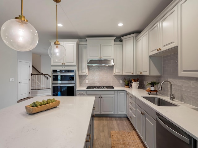 3064 N Spurway Dr, Ann Arbor, MI 48105 - kitchen with stainless steel appliances, wood finished floors, tasteful backsplash, under cabinet range hood, and recessed lighting
