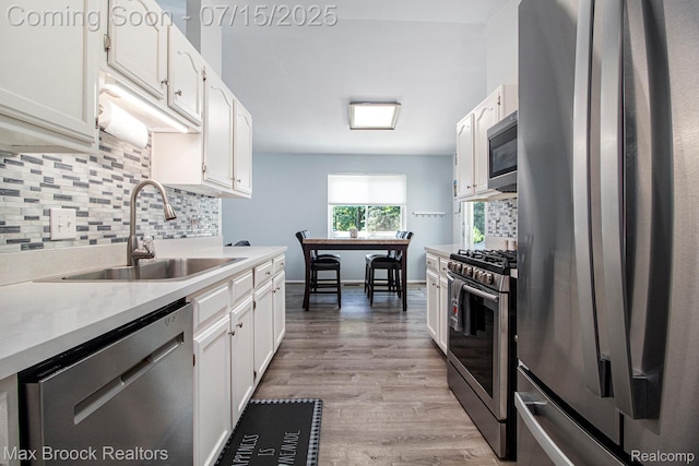 761 Stoney Dr, South Lyon, MI 48178 - kitchen with stainless steel appliances, decorative backsplash, white cabinets, and light countertops