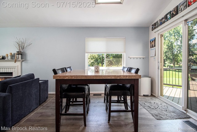 761 Stoney Dr, South Lyon, MI 48178 - dining space featuring wood finished floors and a warm lit fireplace