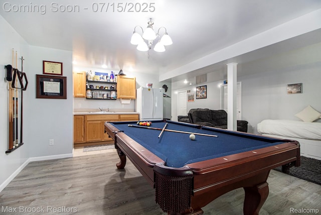 761 Stoney Dr, South Lyon, MI 48178 - playroom featuring bar with sink, wood finished floors, billiards, and a chandelier