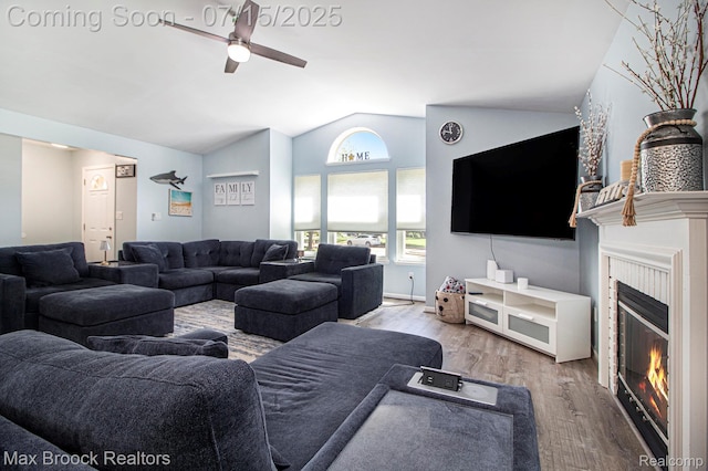 761 Stoney Dr, South Lyon, MI 48178 - living area featuring vaulted ceiling, ceiling fan, a glass covered fireplace, and wood finished floors