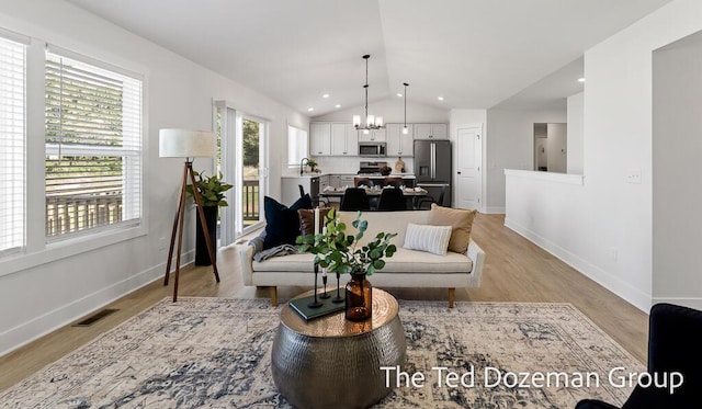 3171 Timberpine Ave, Holland, MI 49424 - living room with a chandelier, lofted ceiling, and light wood finished floors