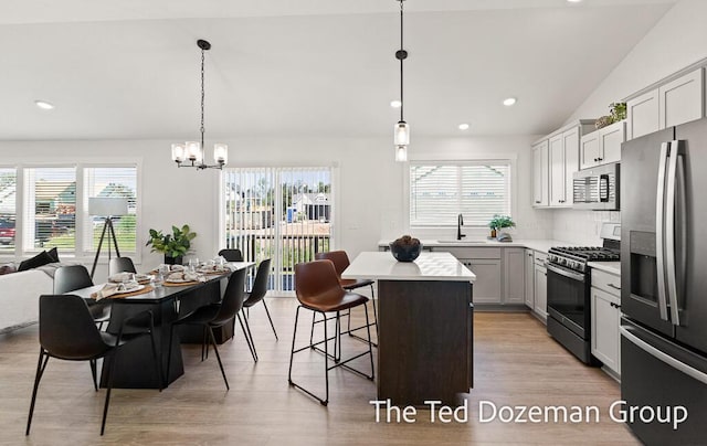 3171 Timberpine Ave, Holland, MI 49424 - kitchen featuring stainless steel appliances, light countertops, a center island, a chandelier, and a kitchen breakfast bar