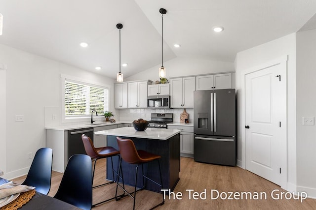 3171 Timberpine Ave, Holland, MI 49424 - kitchen featuring stainless steel appliances, light countertops, decorative backsplash, light wood finished floors, and lofted ceiling