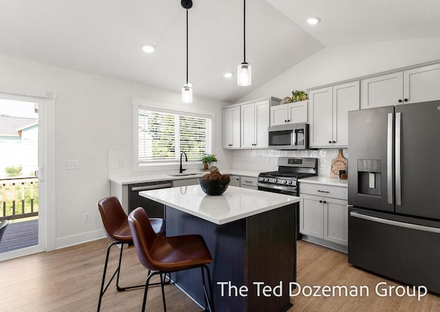 3171 Timberpine Ave, Holland, MI 49424 - kitchen featuring appliances with stainless steel finishes, a breakfast bar, decorative backsplash, lofted ceiling, and light countertops