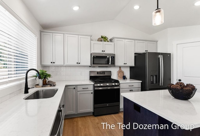 3171 Timberpine Ave, Holland, MI 49424 - kitchen featuring stainless steel appliances, lofted ceiling, light stone counters, light wood-style flooring, and decorative backsplash
